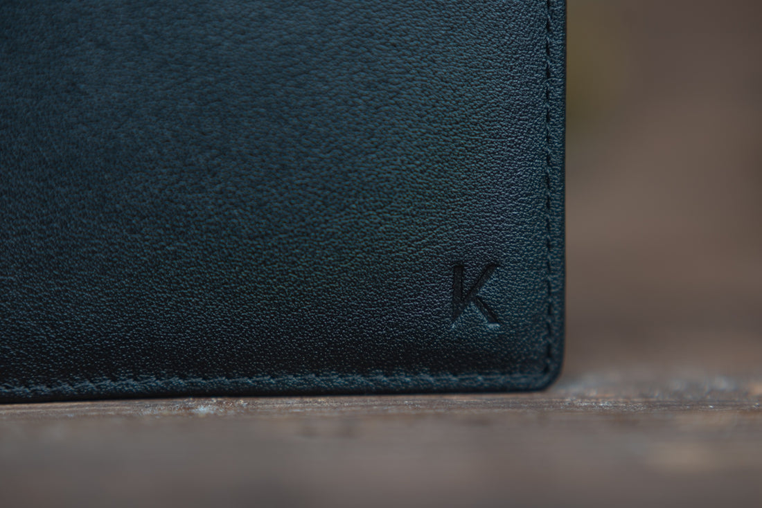 black leather bifold wallet on white table