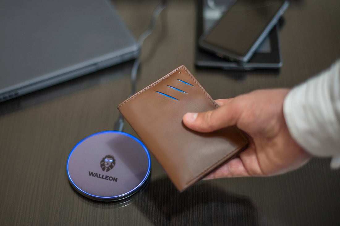 a person holding a wallet next to a laptop