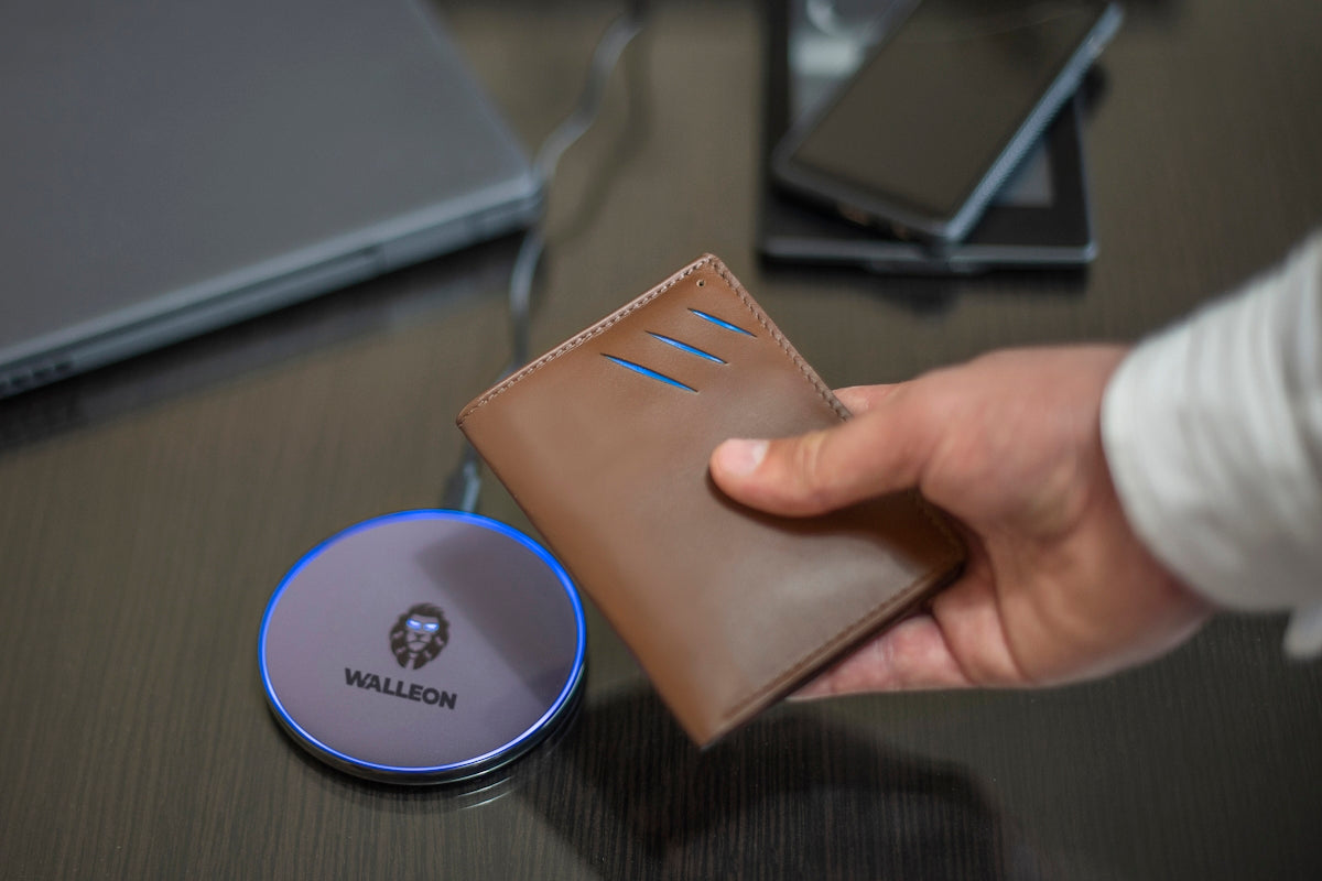 a person holding a wallet next to a laptop