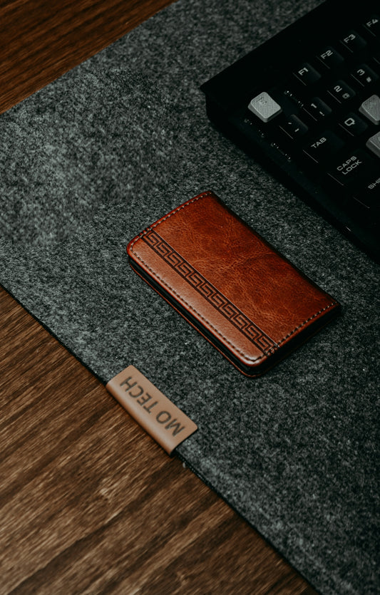 a brown wallet sitting on top of a wooden table