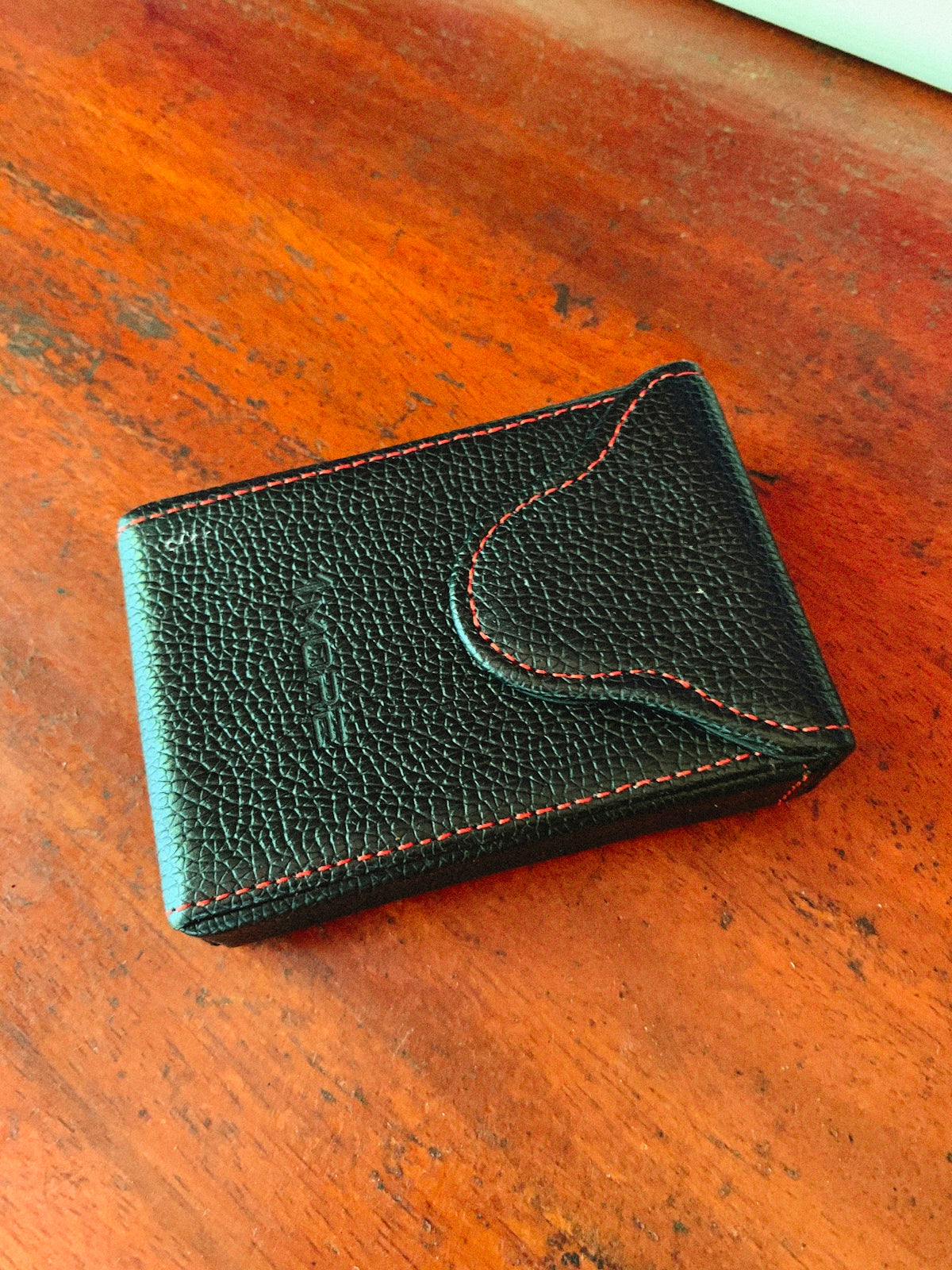 a black leather wallet on a wooden surface