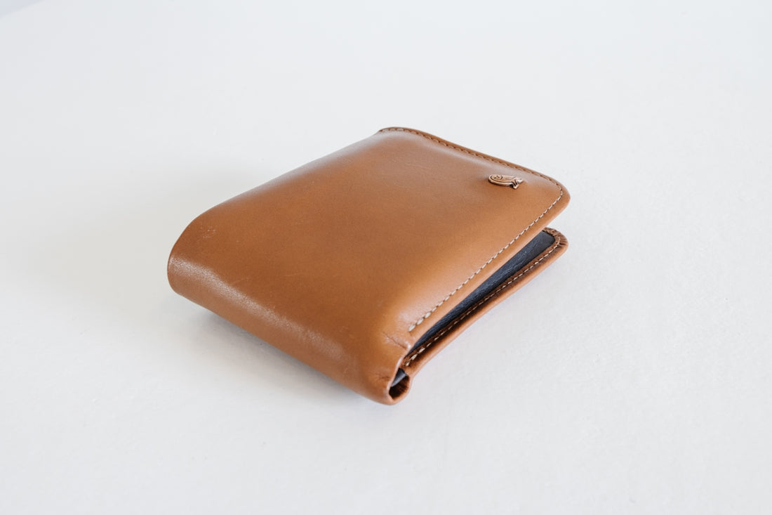 a brown wallet sitting on top of a white table