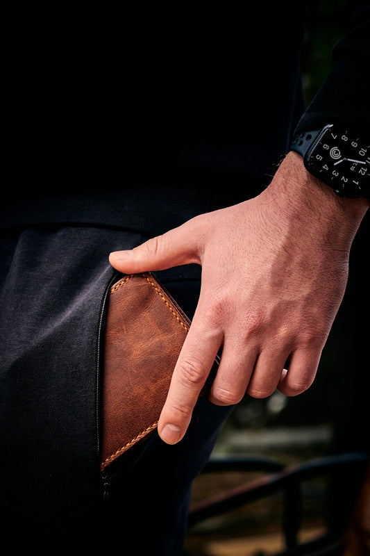 a man is holding his wallet in his pocket