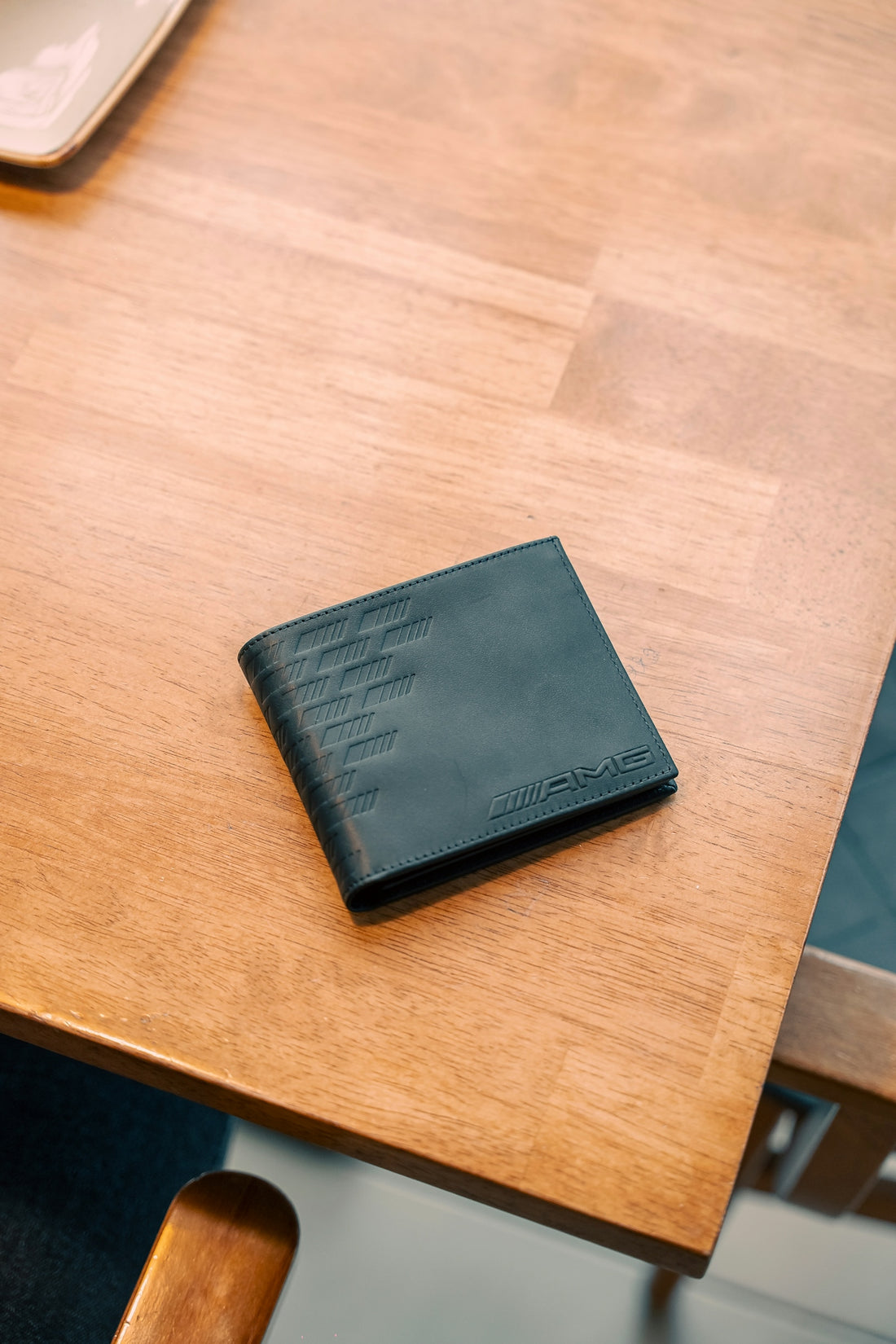 Black wallet with amg logo on wooden table